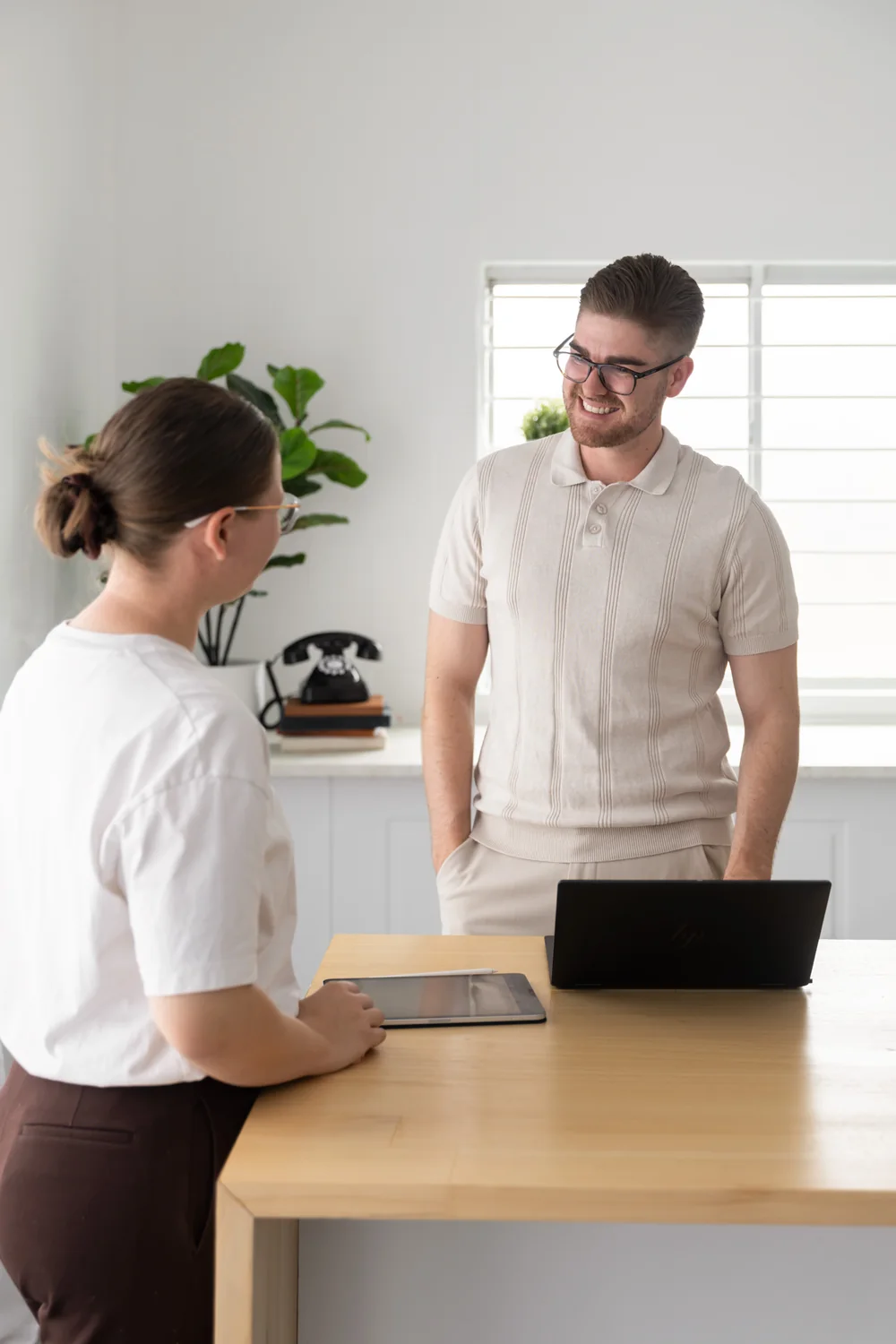 Ethan and Shenae talking beside a table with a laptop and tablet
